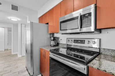 a kitchen with a stove and a microwave at Majestic Penthouse with Ocean and City Views in Miami