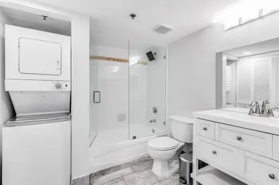 a white bathroom with a toilet and a sink at Majestic Penthouse with Ocean and City Views in Miami