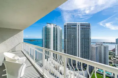 a balcony with white chairs and a view of the city at Majestic Penthouse with Ocean and City Views in Miami