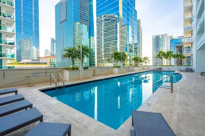 a swimming pool on the roof of a building with tall buildings at Majestic Penthouse with Ocean and City Views in Miami