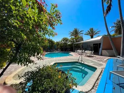 a swimming pool in a yard next to a house at Victoria Park Hotel in Fort Lauderdale