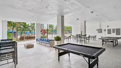 a pool table in a room with tables and chairs at Family Beach Home w Ocean & Bay Views - Upgraded Corner Unit in Miami Beach