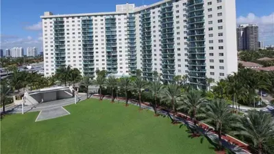 a large building with palm trees and a large lawn at ⌘Family Beach Home w Amazing Water Views - Upgraded Unit ⌘ in Miami Beach