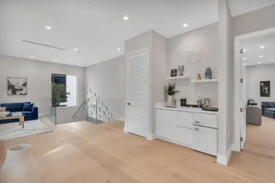 a kitchen and living room with white walls and a blue couch at Villa in Coral Gables with Pool Jacuzzi Game Room in Miami