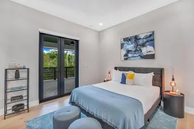 a bedroom with a bed and a large window at Villa in Coral Gables with Pool Jacuzzi Game Room in Miami