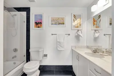 a white bathroom with a toilet and a sink at 3BR Penthouse with European Flair n Amazing Views in Miami