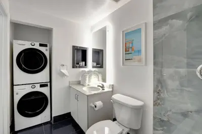 a bathroom with a toilet and a sink and a washing machine at 3BR Penthouse with European Flair n Amazing Views in Miami