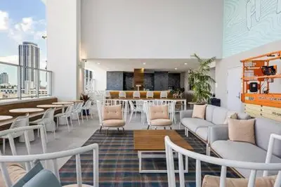 a room with chairs and tables in a building at Explore Miami's Heat - Cozy Studio POOL & GYM in Miami