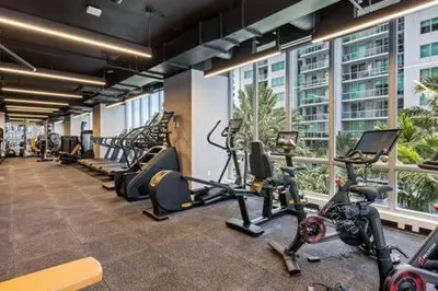a gym with treadmills and ellipticals in a building at Explore Miami's Heat - Cozy Studio POOL & GYM in Miami
