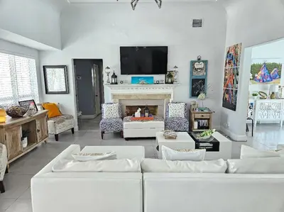 a living room with white couches and a fireplace at Beachside Bliss Pool Retreat Half mile to Beach in Hollywood
