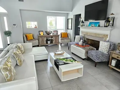 a living room with a white couch and a fireplace at Beachside Bliss Pool Retreat Half mile to Beach in Hollywood