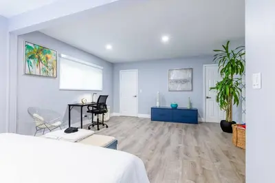 a white room with a bed and a table and chairs at Casa Tropicana - Heated Pool, Game Room & Mins from beach in Hallandale Beach