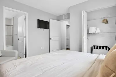 a white bedroom with a bed and a chair at Sistrunk Shades Villa #4 - Townhome Downtown Fort Lauderdale Near Cruise Port & FLL in Fort Lauderdale