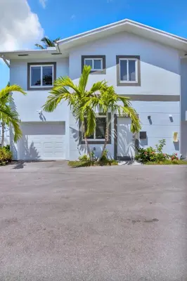 a white house with palm trees in front of it at Sistrunk Shades Villa #5 - New Townhome in Downtown Fort Lauderdale in Fort Lauderdale