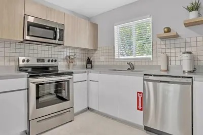 a kitchen with stainless steel appliances and a microwave at Sistrunk Shades Villa #5 - New Townhome in Downtown Fort Lauderdale in Fort Lauderdale