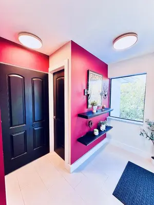 a bathroom with red walls and a black door at Stay Central: Relax in Our Heated Pool Oasis in Miami