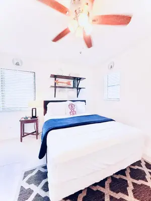a white bedroom with a bed and a ceiling fan at Stay Central: Relax in Our Heated Pool Oasis in Miami