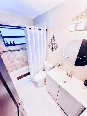 a white bathroom with a toilet and a sink at Stay Central: Relax in Our Heated Pool Oasis in Miami