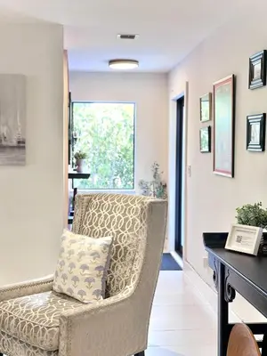 a living room with a chair and a desk at Stay Central: Relax in Our Heated Pool Oasis in Miami