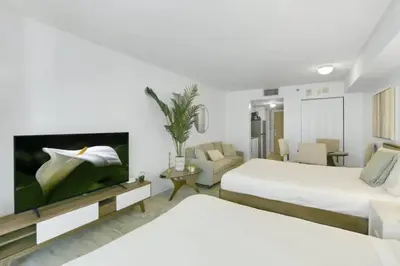 a hotel room with two beds and a tv at Glam Studio: Sleeps 4 x Pool x Gym x Parking in Miami