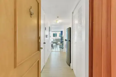 a hallway with white walls and an open door at Glam Studio: Sleeps 4 x Pool x Gym x Parking in Miami