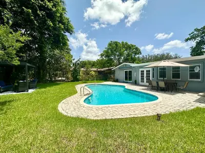 a backyard with a swimming pool and a house at Oasis in Plantation South Florida in Plantation