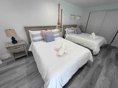 two beds in a room with white and blue at Oasis in Plantation South Florida in Plantation