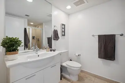 a white bathroom with a toilet and a sink at LUX 2B-2B at ICON - Water View & 5-Star Amenities in Miami