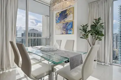 a dining room with a glass table and white chairs at LUX 2B-2B at ICON - Water View & 5-Star Amenities in Miami
