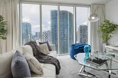 a living room with a white couch and a large window at LUX 2B-2B at ICON - Water View & 5-Star Amenities in Miami