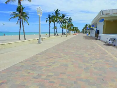 a brick sidewalk next to a beach with palm trees at 316 Footloose #3 in Hollywood