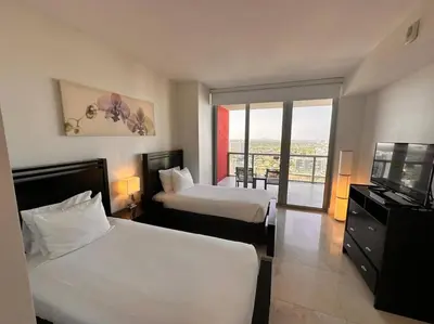 a hotel room with two beds and a flat screen tv at 3Bed/2Bath Hallandale Beach in Hallandale Beach