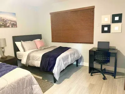 a bedroom with a bed and a desk and a window at GREAT LOCATION Downtown/Airport/South Beach in Miami
