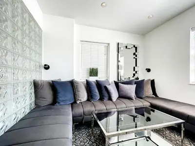 a living room with a brown couch and a glass table at CasaGrandeSouthBeach by AmericanVacationLiving 4RM in Miami Beach