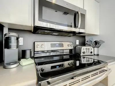 a kitchen with a stove and a microwave at CasaGrandeSouthBeach by AmericanVacationLiving 4RM in Miami Beach