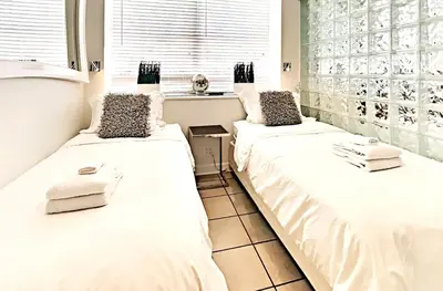 two beds sitting next to each other in a room at CasaGrandeSouthBeach by AmericanVacationLiving 4RM in Miami Beach