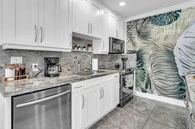 a kitchen with white cabinets and a mural at Miami Luxury Home! Next to Miami airport and beach in Miami