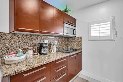 a kitchen with wooden cabinets and a counter top at Miami Cozy Home! Next to Miami beach & Airport in Miami