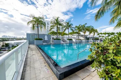a swimming pool on the roof of a building with palm trees at High Floor Luxury 2BR 2BA, Sleeps 6, Resort Access - Horizon by HomeStakes Stays in Fort Lauderdale