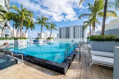 a swimming pool with palm trees and a resort at High Floor Luxury 2BR 2BA, Sleeps 6, Resort Access - Horizon by HomeStakes Stays in Fort Lauderdale