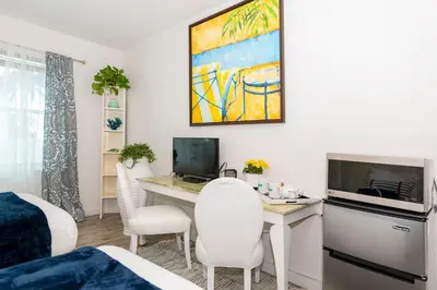 a room with a desk with a computer and chairs at 6768 Collins Miami Stays in Miami Beach