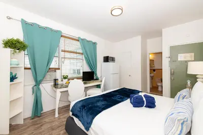 a bedroom with a bed and a desk with a computer at 6768 Collins Miami Stays in Miami Beach