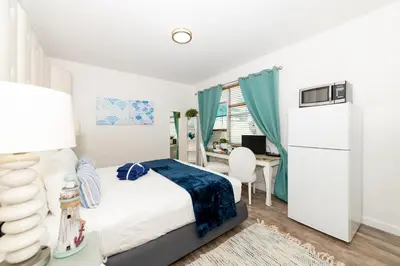 a bedroom with a bed and a desk at 6768 Collins Miami Stays in Miami Beach