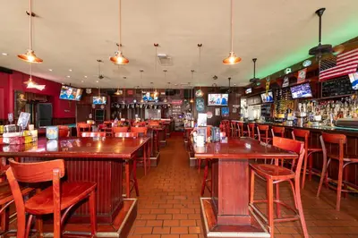 a bar with wooden tables and chairs in a restaurant at 6768 Collins Miami Stays in Miami Beach