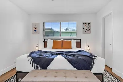 a bedroom with a large bed and a window at Centrally Located 4BDR Pool Home in Miami in Miami Gardens