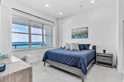 a bedroom with a bed and a large window at OceanFront Luxury Penthouse 2 Bedrooms with Direct Ocean View in Miami Beach