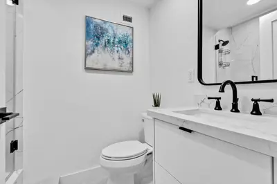 a white bathroom with a toilet and a mirror at OceanFront Luxury Penthouse 2 Bedrooms with Direct Ocean View in Miami Beach