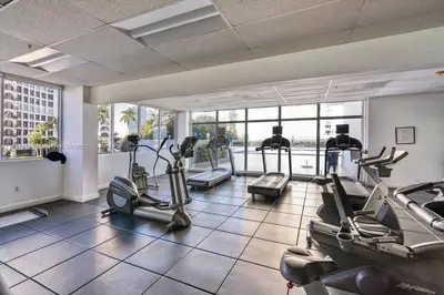 a gym with several treadmills and elliptical machines at OceanFront Luxury Penthouse 2 Bedrooms with Direct Ocean View in Miami Beach