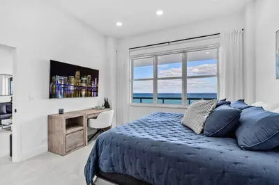 a bedroom with a bed and a desk and a window at OceanFront Luxury Penthouse 2 Bedrooms with Direct Ocean View in Miami Beach