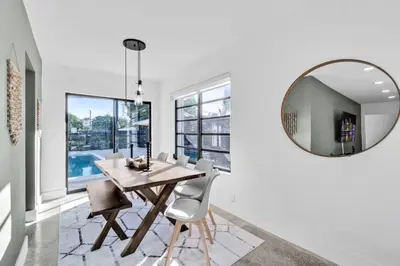 a dining room with a table and a mirror at Modern Pool Home Great for Families in Hollywood